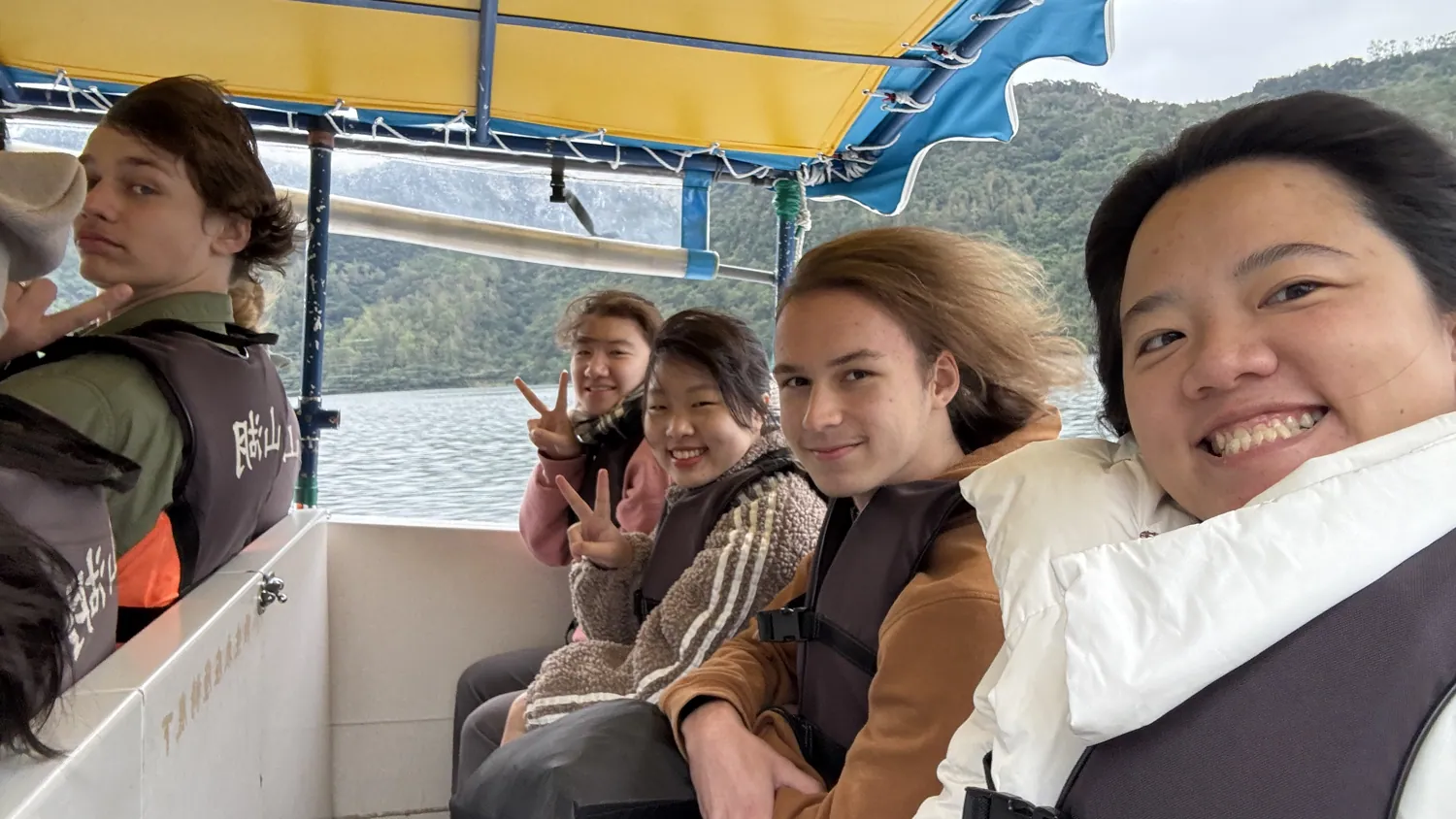 Students on a boat trip among misty green mountains in Taiwan