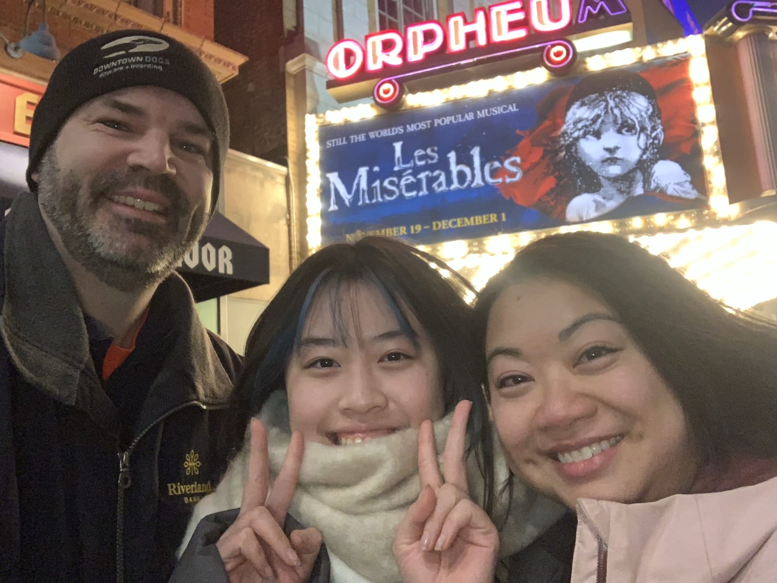 三人在劇院外與音樂劇招牌合照