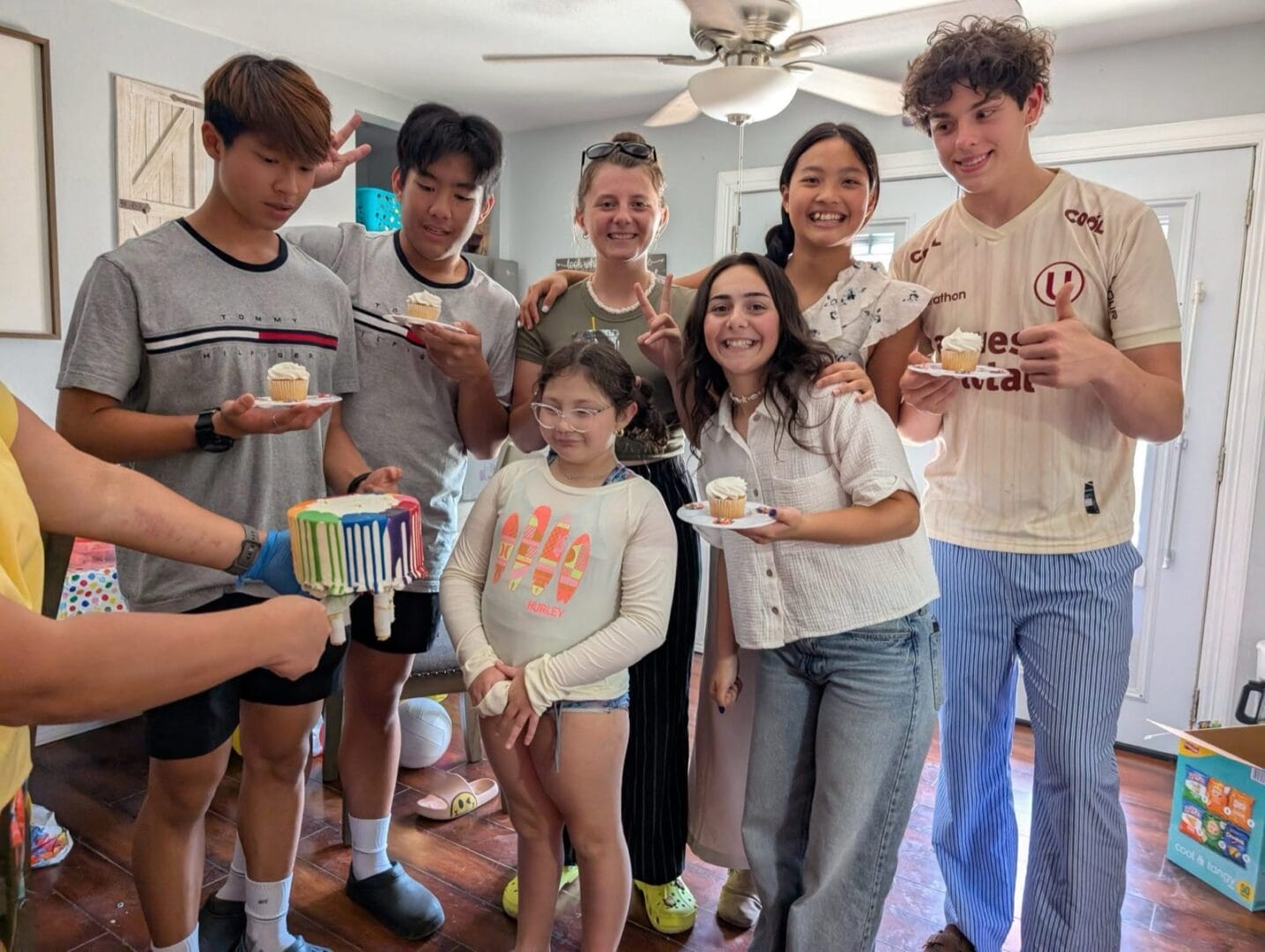 一群朋友在室內圍著生日點心合照